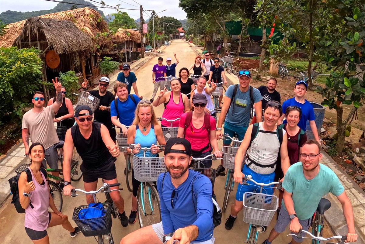Cat Ba Lan Ha Bay bike tour group cycling through a village